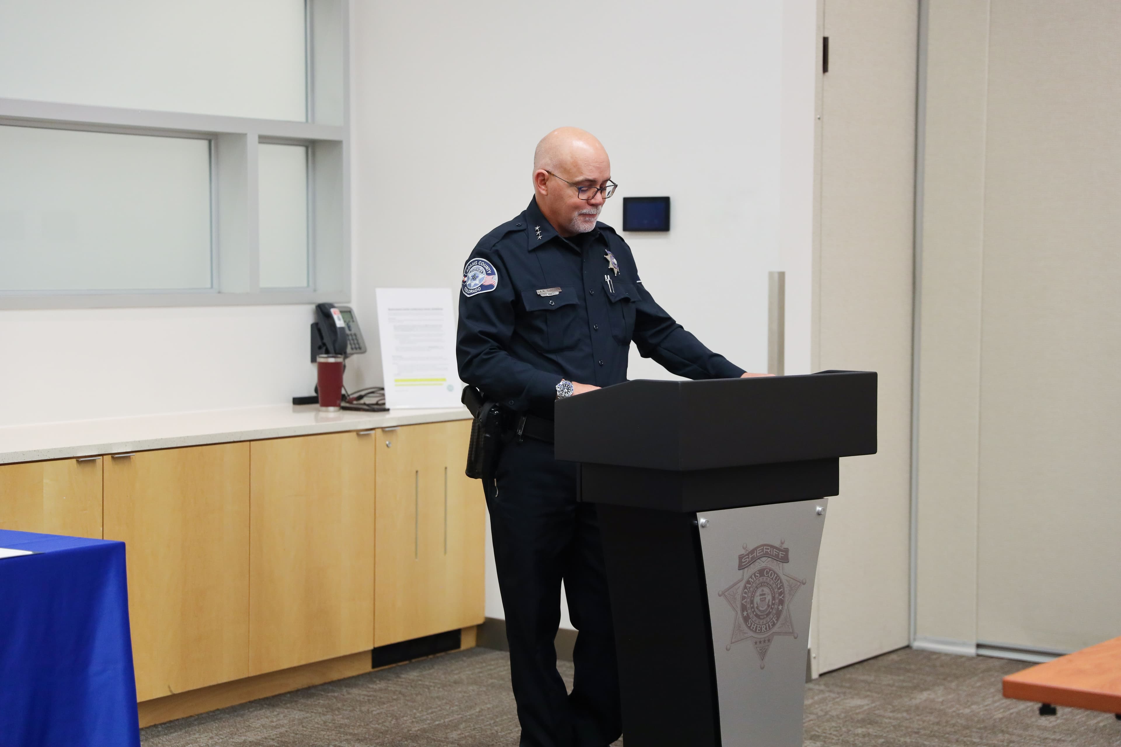 Undersheriff Kevin Currier speaking at a podium during the 2026 scholarship presentation.